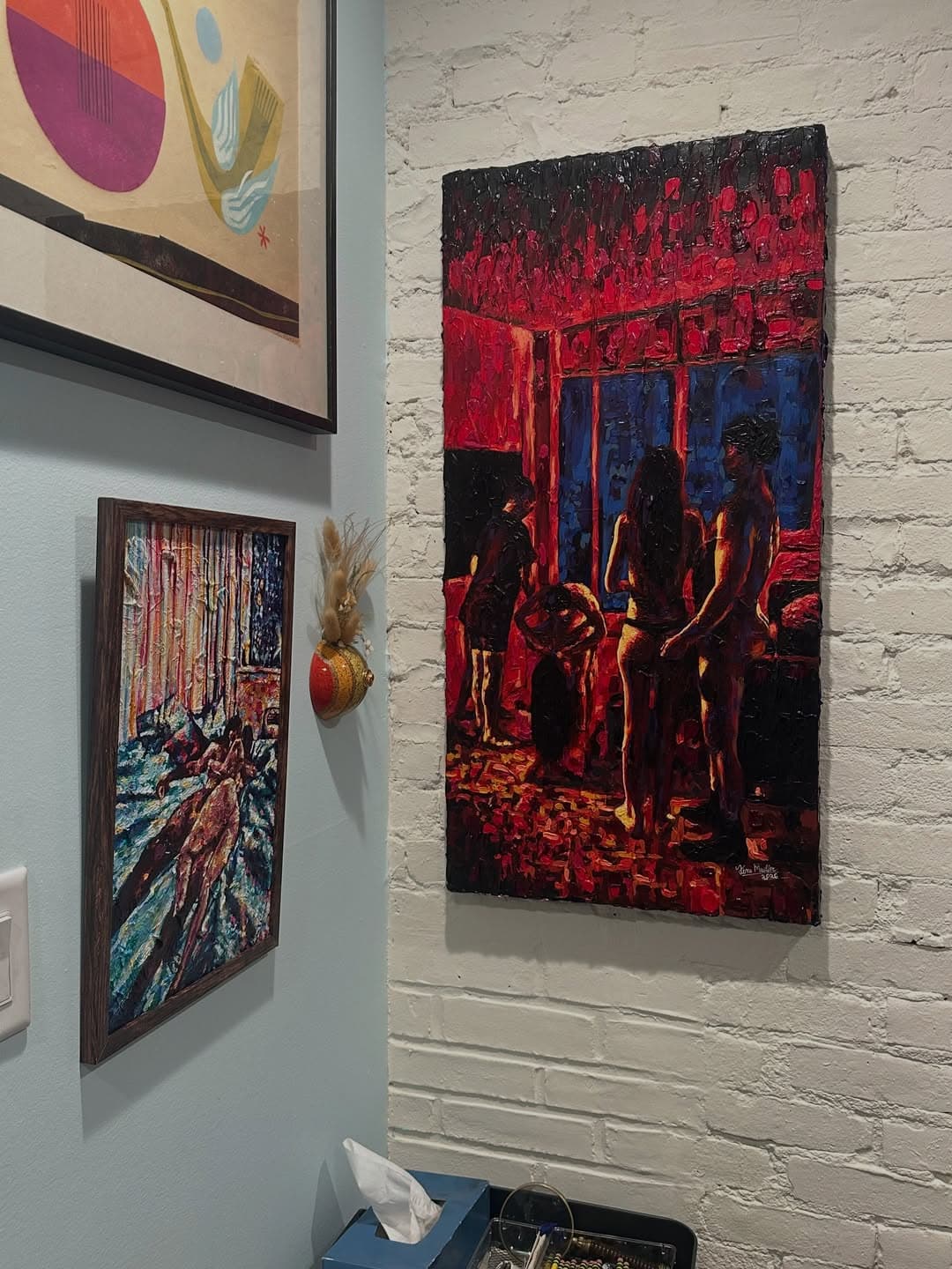 Toni Mueller paintings installed against white brick