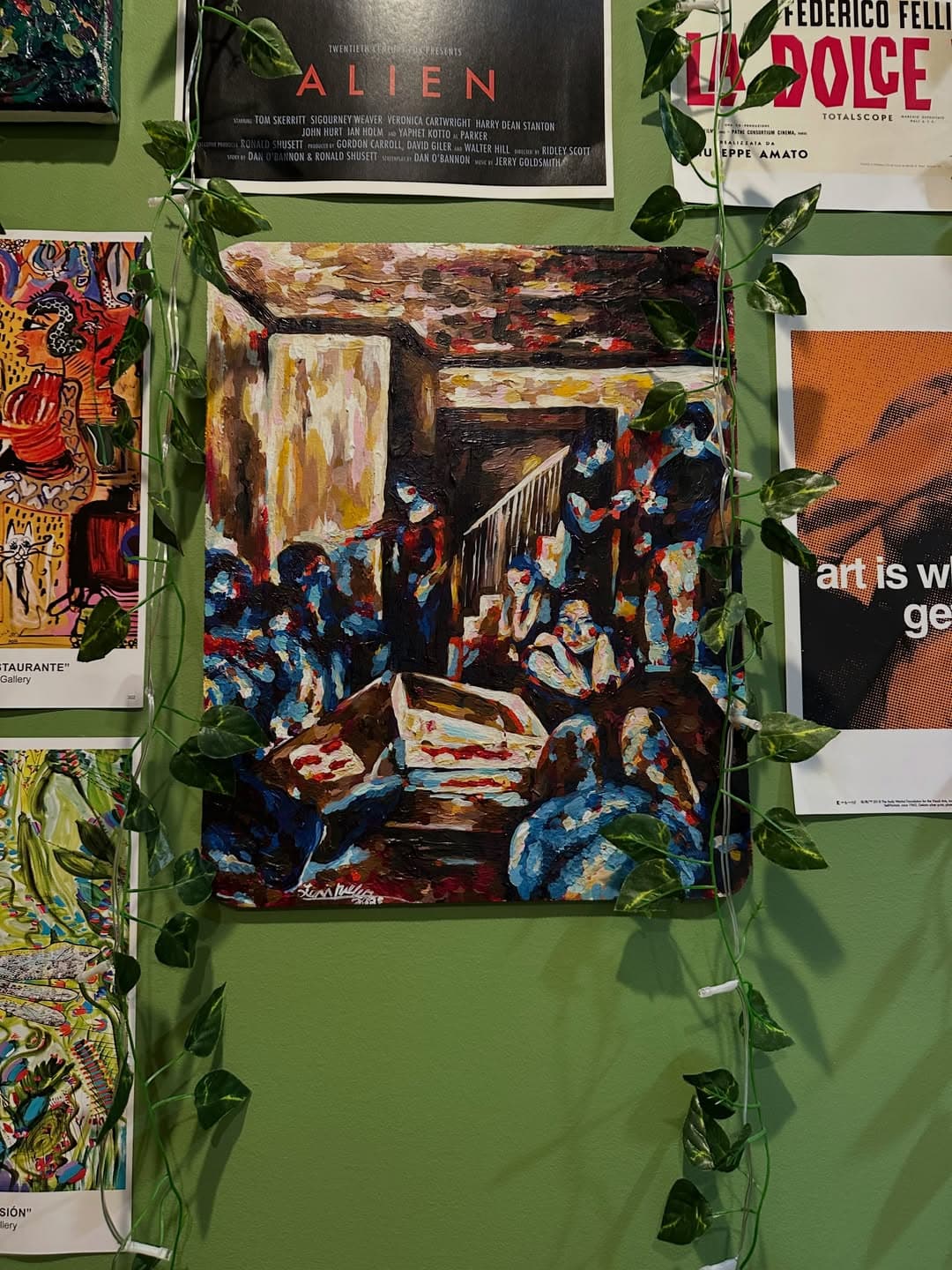 A live-scene painting installed among film posters and vines